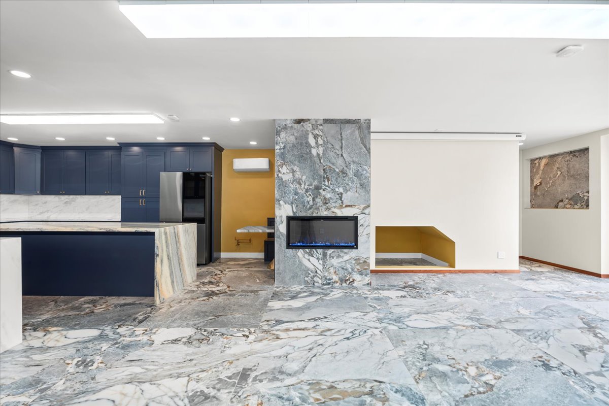 Open concept living to kitchen transition with large format Italian porcelain tile